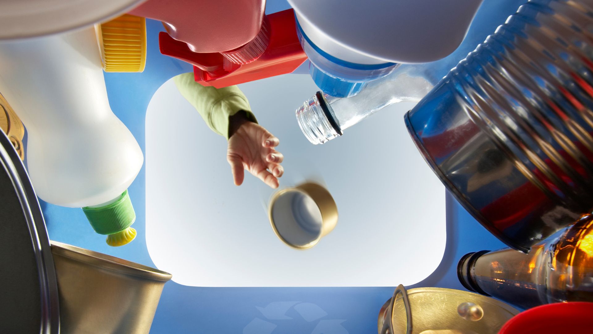 Hand reaching for objects from below, colorful bottles and containers