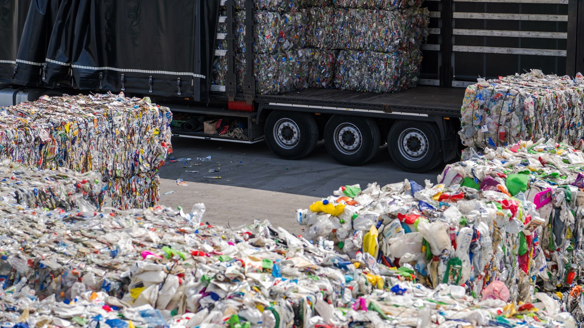 Recycling truck with large compressed bales of colorful plastic waste