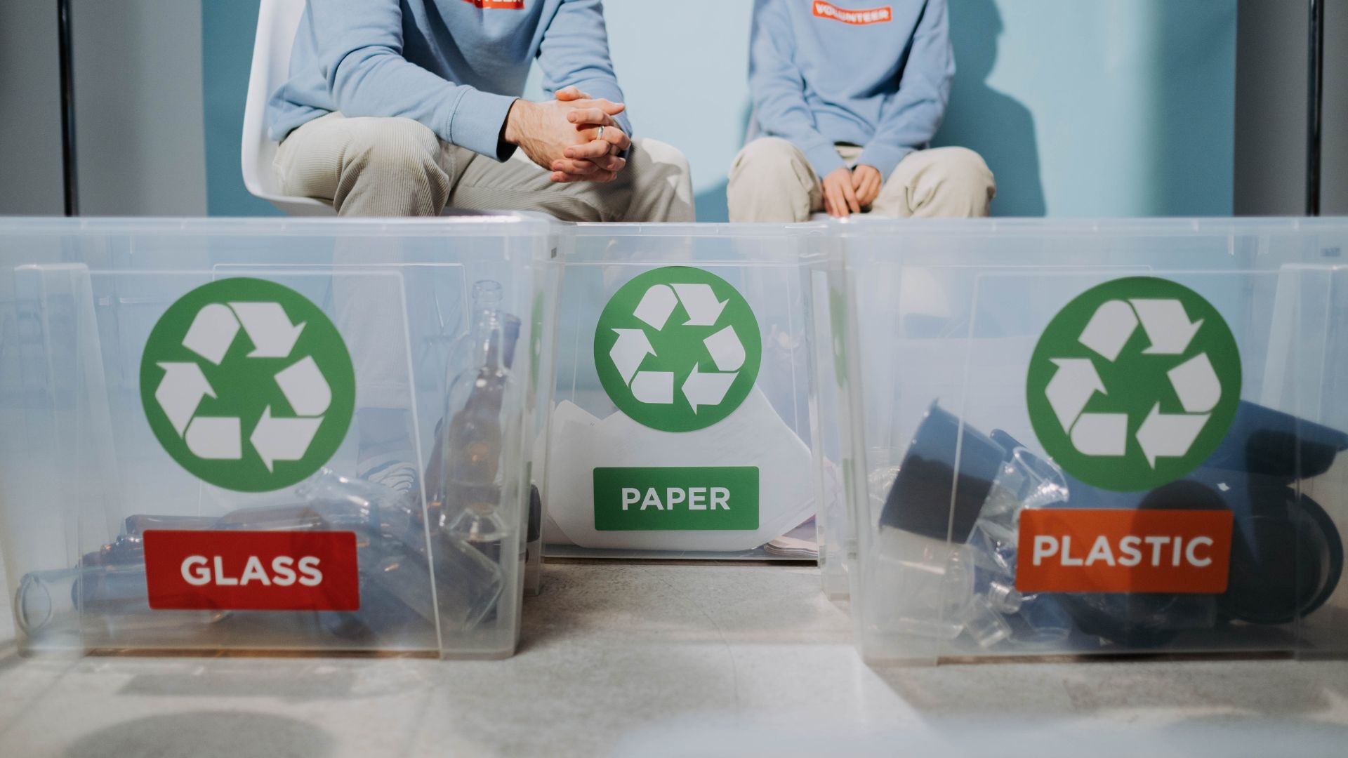 Recycling bins for glass, paper, and plastic with sorting volunteers